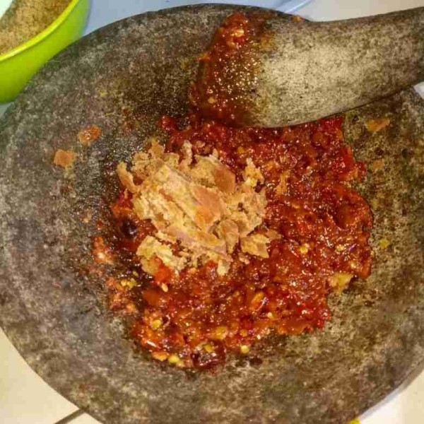 Sisir gula merah kemudian masukkan ke dalam cobekan. Haluskan sampai tercampur rata.