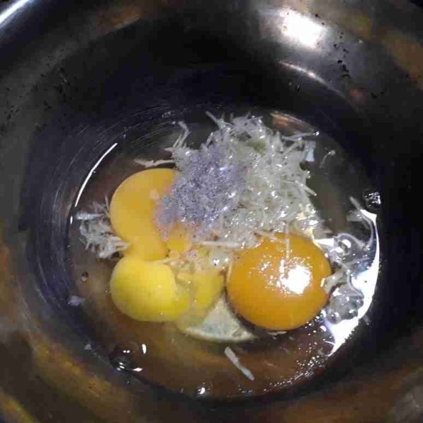 Pecahkan telur, masukkan bawang putih parut, sedikit lada bubuk, dan garam, kocok rata.