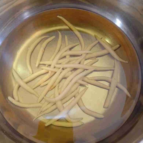 Ambil sedikit adonan kemudian plintir menggunakan kedua telapak tangan lalu masukkan adonan yang sudah diplintir tadi ke dalam wajan yang berisi minyak dingin. Lakukan hingga kira-kira adonan sudah pas untuk sekali digoreng saja.