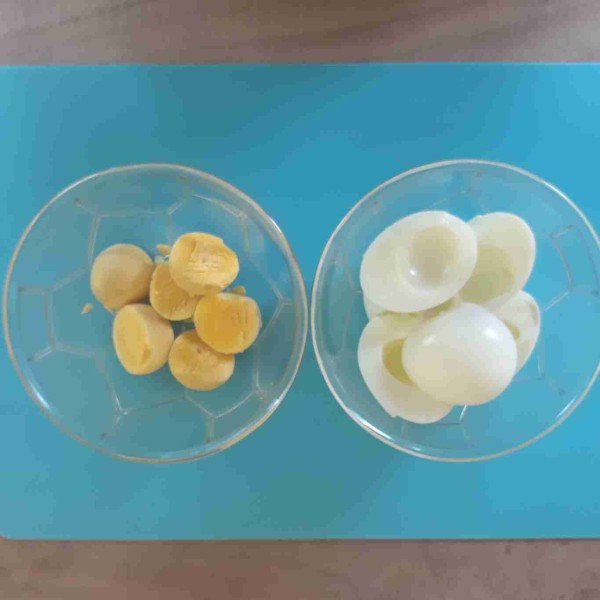 Kupas telur rebus kemudian potong jadi dua bagian, lalu pisahkan putih dan kuning telurnya.