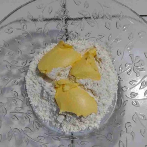 Tuang tepung terigu ke dalam wadah kemudian tambahkan 3 sdm margarin. Aduk dengan garpu sampai rata.