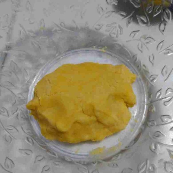 Tambahkan 1 butir kuning telur, aduk dengan garpu lalu uleni sebentar dengan tangan namun tidak sampai kalis.