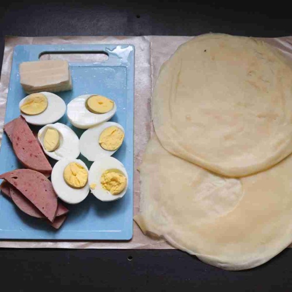Siapkan bahan lembaran kulit risoles, telur yang telah dibagi menjadi 2, smoked beef rebus yang telah dibagi menjadi 6 bagian, serta keju yang telah dibagi 6 bagian.