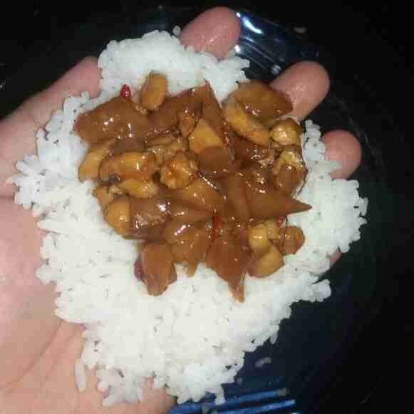 Ambil segenggam nasi, beri isian 1 sdm. Ambil segenggam nasi lagi, tutup hingga bagian isiannya tertutup.