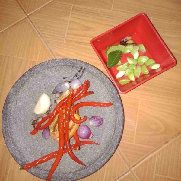 Goreng bawang merah, bawang putih, tomat, dan cabai agar gampang diulek. Kupas pete potong jadi 2 bagian.