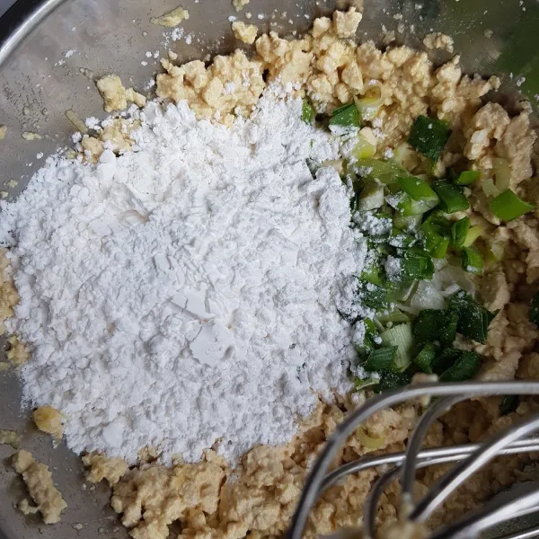 Tambahkan tepung tapioka dan daun bawang. Aduk rata.