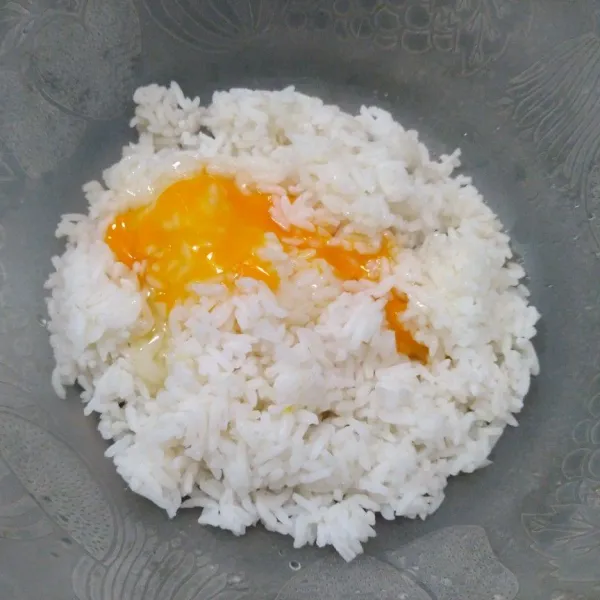 Pecahkan telur kemudian masukkan dalam wadah nasi.