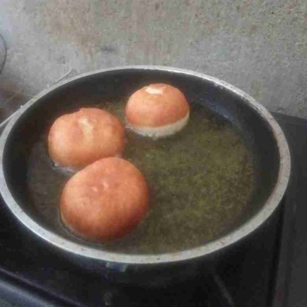 Panaskan minyak goreng. Lepaskan donat dari kertas roti lalu masukkan ke dalam minyak panas dengan api sedang cenderung kecil. Jika satu sisi sudah kecoklatan langsung dibalik sekali saja. Angkat lalu dinginkan. Sajikan.