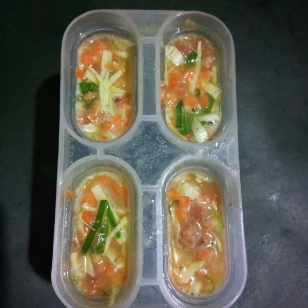 Oles cetakan es loli dengan minyak goreng lalu tuang adonan telur hingga penuh.