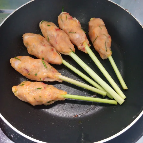 Lilitkan adonan pada batang serai kemudian panggang di atas teflon sampai matang. Angkat dan sajikan.