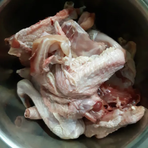 Potong 1 ekor ayam menjadi 4 bagian kemudian cuci hingga bersih.