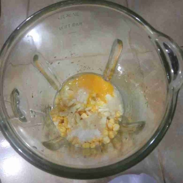 Masukkan jagung, bawang putih, telur, air jeruk, garam, dan gula ke dalam blender. Beri sedikit air lalu blender.