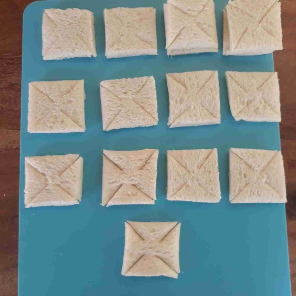 Potong roti tawar jadi 4 bagian. Potong diagonal sudut-sudutnya tanpa putus.