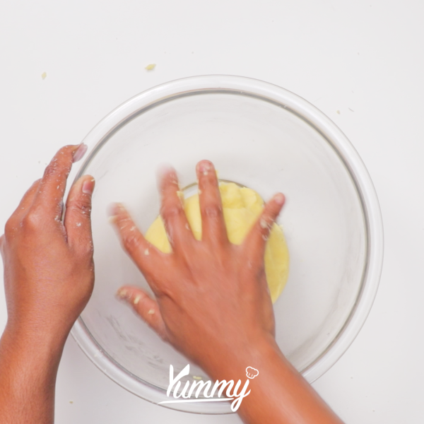 Campurkan tepung terigu, gula halus, garam dan susu bubuk dalam mangkuk lalu aduk hingga rata. Setelah itu tambahkan mentega yang telah didinginkan di dalam kulkas terlebih dahulu lalu haluskan dengan tangan hingga berbentuk seperti pasir. Tambahkan kuning telur dan air dingin yang telah dikocok lalu uleni hingga tercampur (jangan sampai kalis). Tutup dengan plastik wrap lalu resting dalam kulkas selama 20 menit.