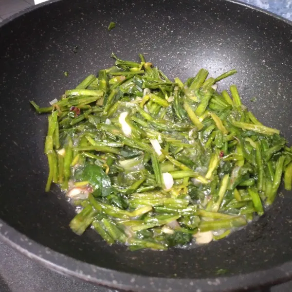 Masukkan genjer, aduk beberapa saat lalu masukkan secukupnya air.