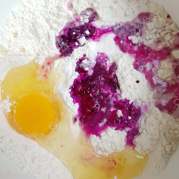 Masukkan telur, buah naga yang sudah dihaluskan, dan sedikit demi sedikit air dingin. Uleni hingga kalis (jika air belum habis namun adonan sudah kalis, berhenti menambahkan air).