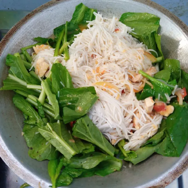 Masukkan bihun dan sawi. Aduk rata. Masak sampai sawi layu. Angkat dan sajikan.