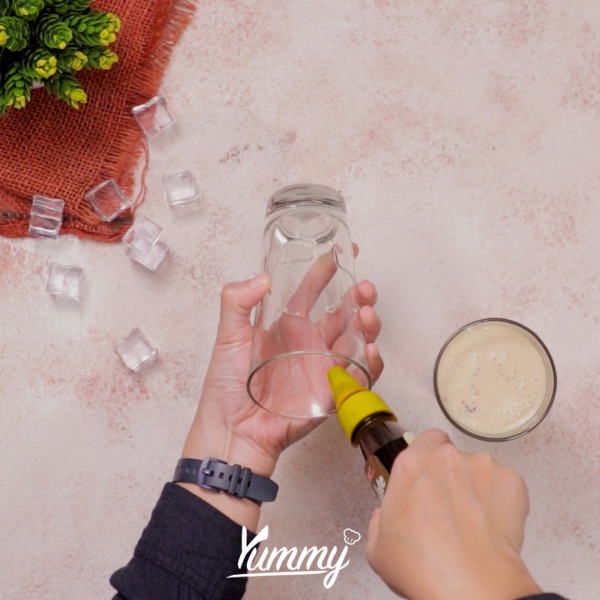 Siapkan gelas, beri saus coklat di sisi dinding gelasnya, kemudian tuangkan minuman kedalamnya.