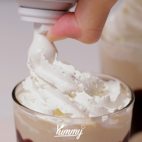 Beri topping whip cream, taburan bubuk coklat, dan biskuit lady finger. Tiramisu Milkshake siap untuk disajikan.