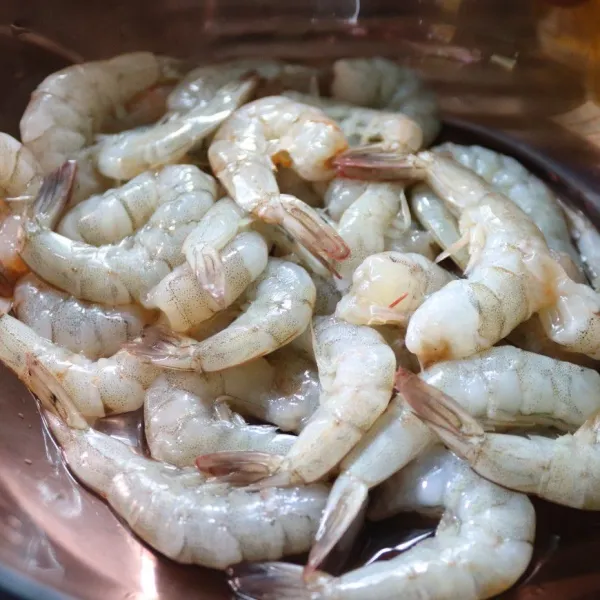 Siapkan udang lalu kupas kulit dan beri perasan jeruk nipis.