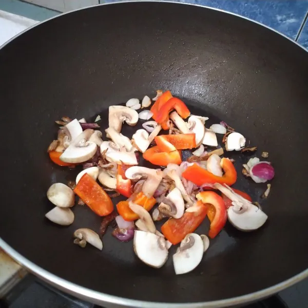 Tumis bawang merah hingga harum dan layu. Masukkan paprika dan jamur. Masak hingga layu lalu tambahkan secukupnya air. Aduk dan masak hingga air mendidih.