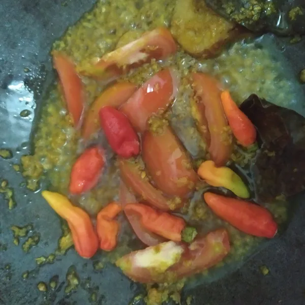 Masukkan tomat dan cabai rawit merah, masak sampai cabai layu.