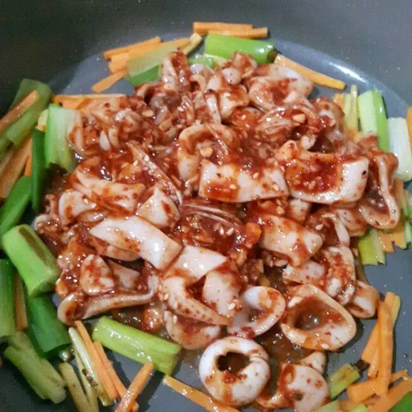 Panaskan minyak sayur. Masukkan bawang bombay, wortel, daun bawang, dan cabai hijau. Tumis sampai bombay terlihat sedikit transparan. Tepikan tumisan sayur. Tuang cumi yang tadi sudah dimarinasi sauce dibagian tengah wajan lalu aduk rata. Tumis sampai cumi matang. Jangan memasak cumi terlalu lama, karena jika terlalu lama cumi bisa alot. Tambahkan garam jika perlu. Koreksi rasa, angkat.