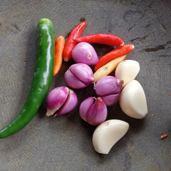 Siapkan cabe, bawang merah dan bawang putih di atas cobek.