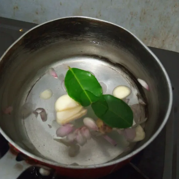 Panaskan air, masukkan bawang merah, bawang putih, kencur dan daun jeruk. masak sampai mendidih
