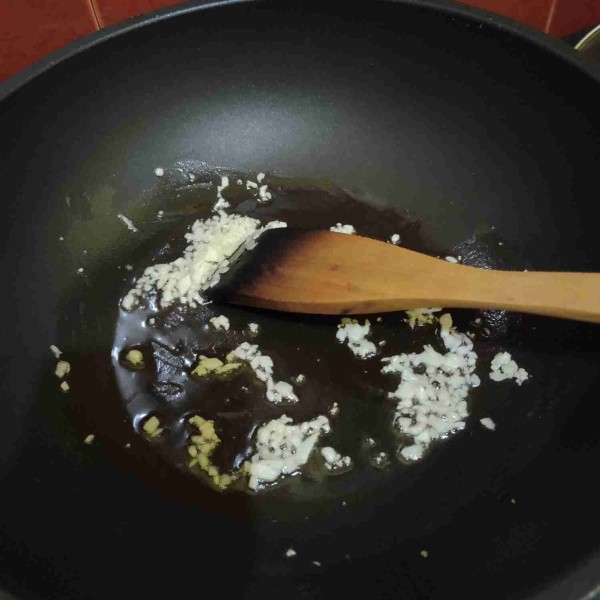 Tumis bawang putih cincang dengan sedikit minyak hingga harum