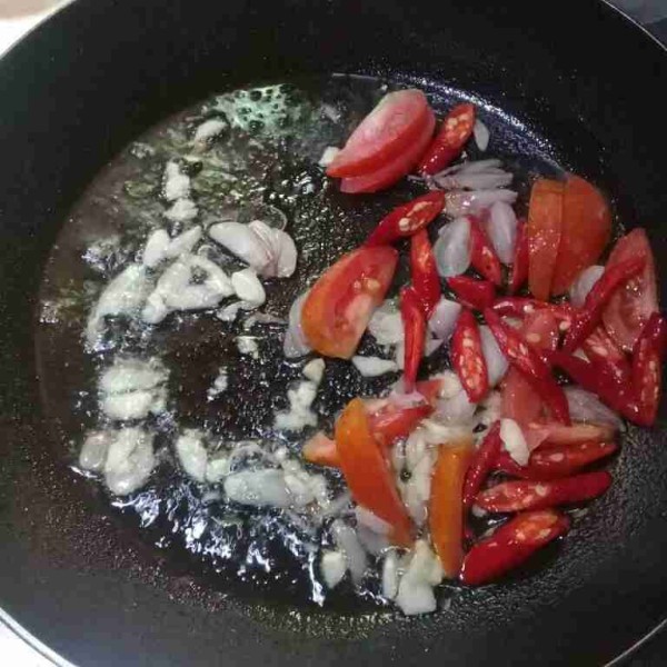 Tumis bawang merah, bawang putih, tomat, dan cabe merah sampai harum.