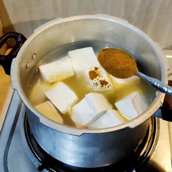 Masukkan dalam Panci, Tahu putih, Air, Bubuk kari, Bubuk Kaldu, dan garam. Aduk rata.