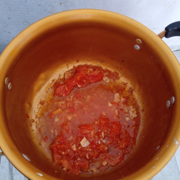 Panaskan minyak lalu tumis bawang putih dan ulekan cabai rawit tomat