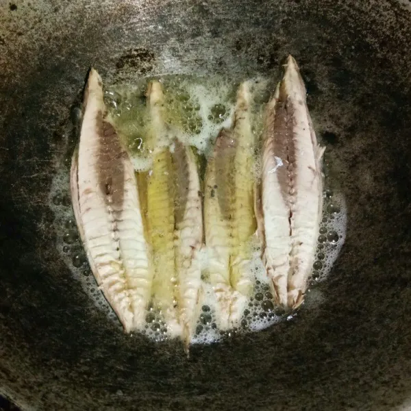 Bersihkan ikan tongkol, buang duri dan kepalanya, kemudian goreng sebentar dalam minyak panas