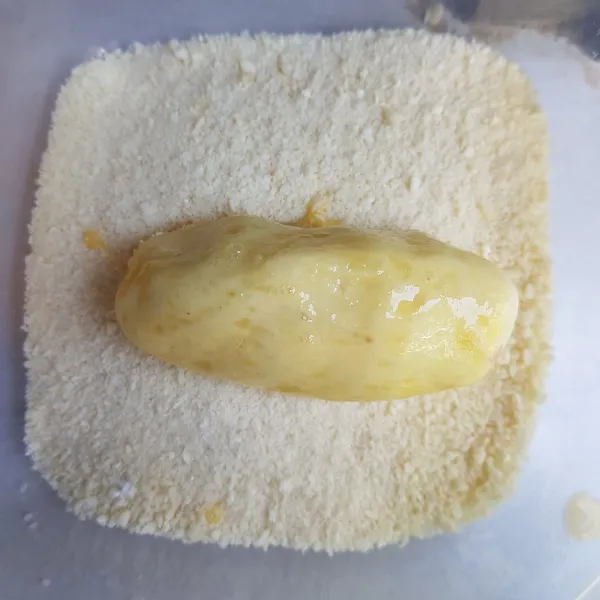 Kemudian gulingkan adonan kroket ke dalam tepung roti. Balut hingga semua bagian tertutupi tepung roti