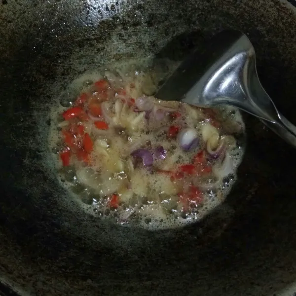 Panaskan secukupnya minyak bekas menggoreng ikan tadi. Lalu tumis cabe rawit, bawang merah dan bawang putih hingga harum