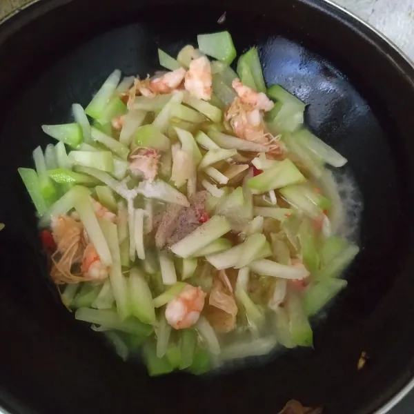 Beri garam, gula, kaldu bubuk, lada bubuk dan air. Aduk rata, koreksi rasa. Masak sampai labu siam matang. Angkat