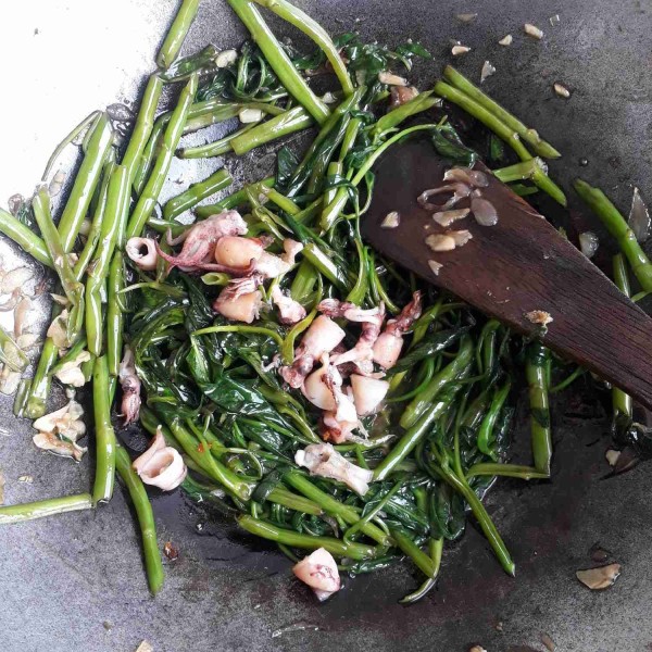 Masukkan kangkung, aduk rata dan koreksi rasa. Masukkan cumi, tomat dan cabai. Aduk rata, sajikan