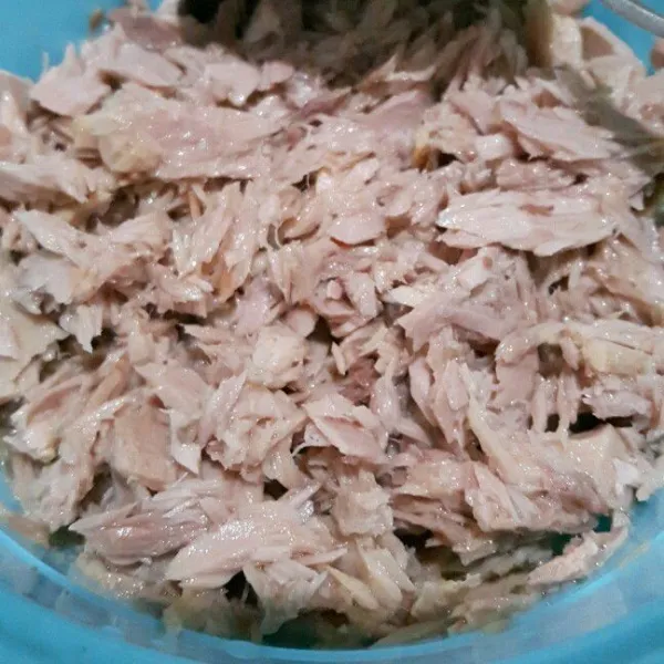 Tiriskan daging tuna dari minyaknya kemudian suwir menggunakan garpu. Sisihkan.