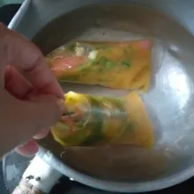 Masukkan sosis ke dalam plastik untuk membuat es mambo. Kemudian masukkan kocokan telur hingga sosis terendam. Panaskan air dan rebus bahan hingga matang