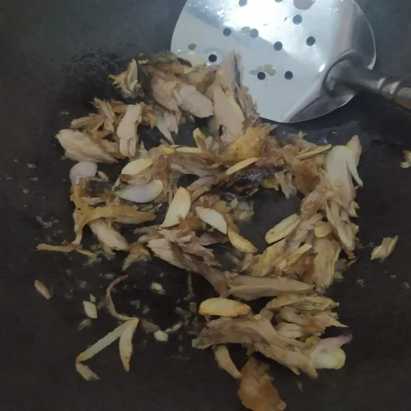 Masukkan ikan tongkol asap yang sudah disuwir, aduk rata