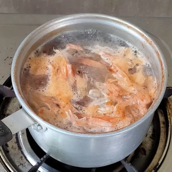 Untuk membuat kuahnya, rebus kulit dan daging udang hingga aroma kaldu menguap