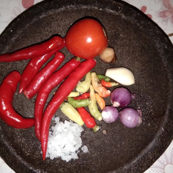 Haluskan 3 siung bawang merah, 1 siung bawang putih,  11 cabe rawit, 6 cabe merah, 1 tomat, 1 cm laos dan garam secukupnya
