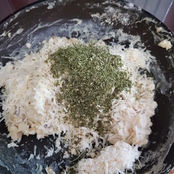 Kemudian tambahkan keju cheddar parut, parmesan dan parsley flakes. Aduk rata dan masak hingga adonan kalis. Koreksi rasa dan tunggu hingga sedikit hangat