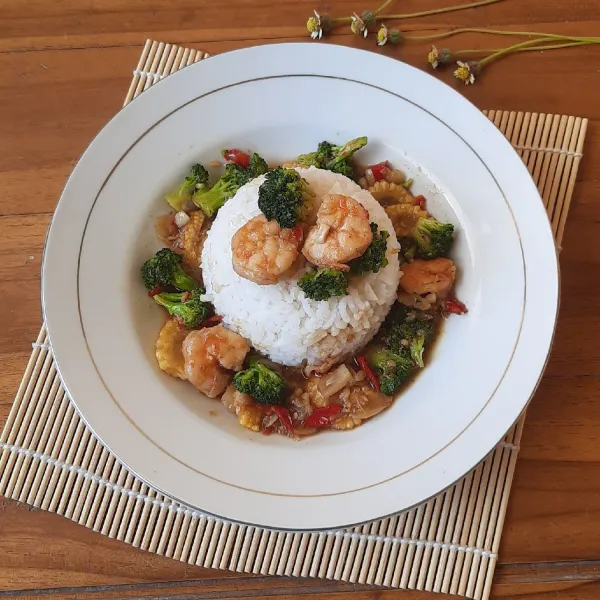 Tata nasi di tempat penyajian, kemudian siram tumisan udang sayur di atasnya. Hidangkan selagi hangat