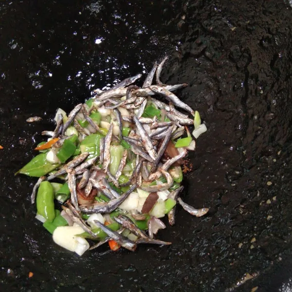 Masukkan 2 bungkus ikan teri lalu ratakan