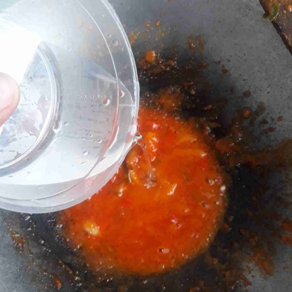 Masukkan saus tomat, saus sambal, garam, merica dan kaldu bubuk. Aduk rata lalu masukkan bawang bombay dan cabai potong. Aduk rata hingga bawang dan cabai layu, beri air kemudian koreksi rasanya