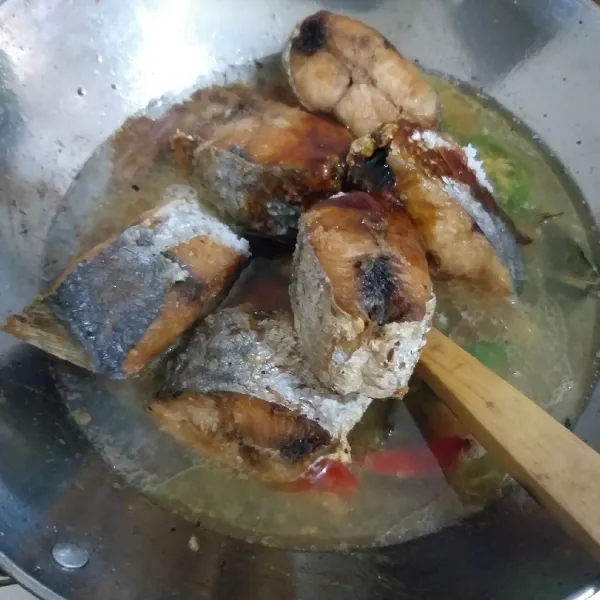 Tambahkan air dan biarkan mendidih. Masukkan ikan goreng dan kecap manis