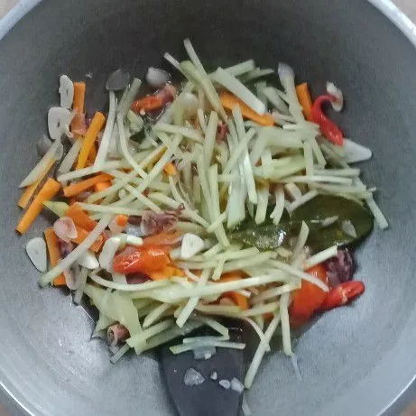 Masukkan air, wortel dan cumi asin. Masak hingga mendidih, lalu masukkan labu siam