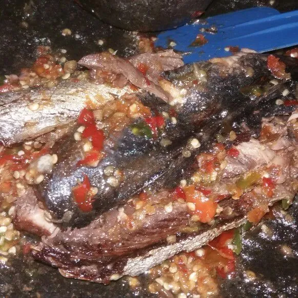 Selanjutnya penyet perlahan ikan di atas sambal, sajikan